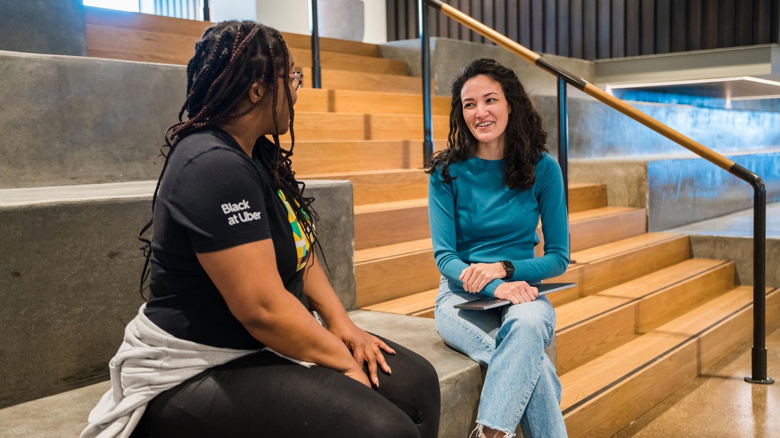 two women sitting on stairs talking