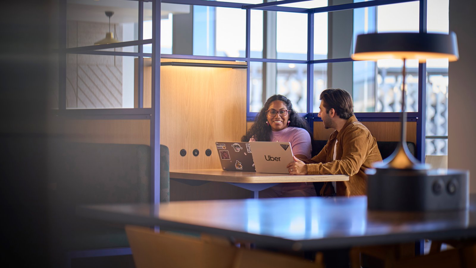 a person and person sitting at a table with laptops