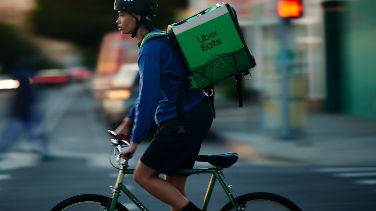 a person riding a bike with a food delivery bag