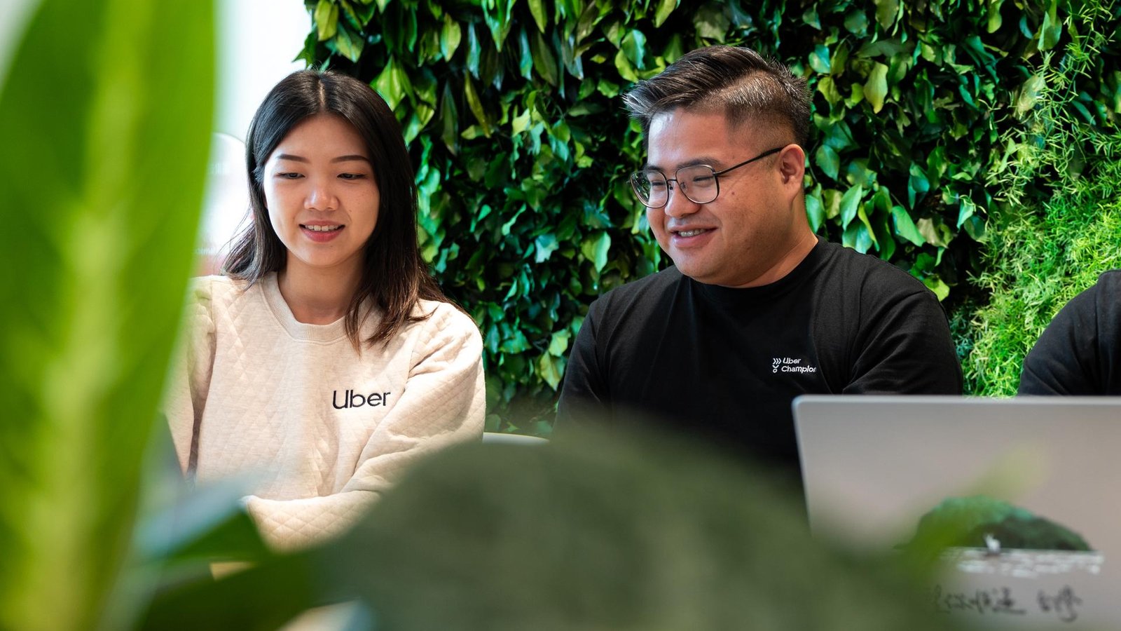a person and person sitting at a table with a laptop