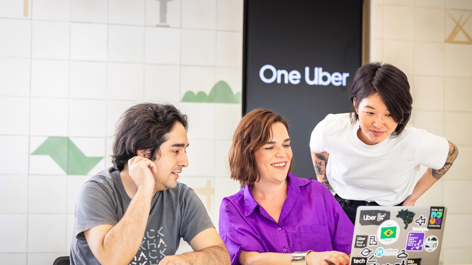 a group of people looking at a laptop