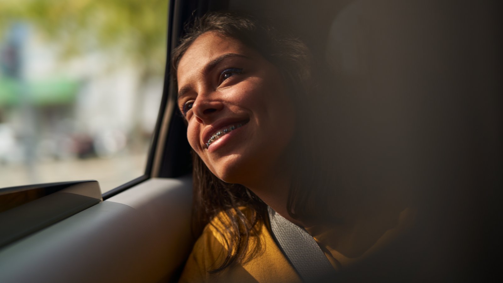 a person smiling looking out a window