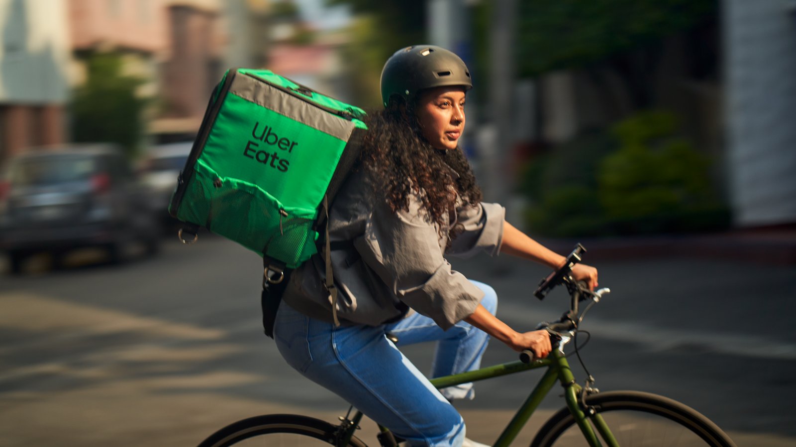 a person riding a bike with a food delivery bag