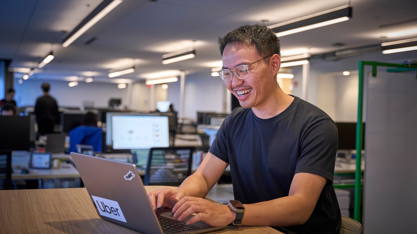 a person smiling at a laptop