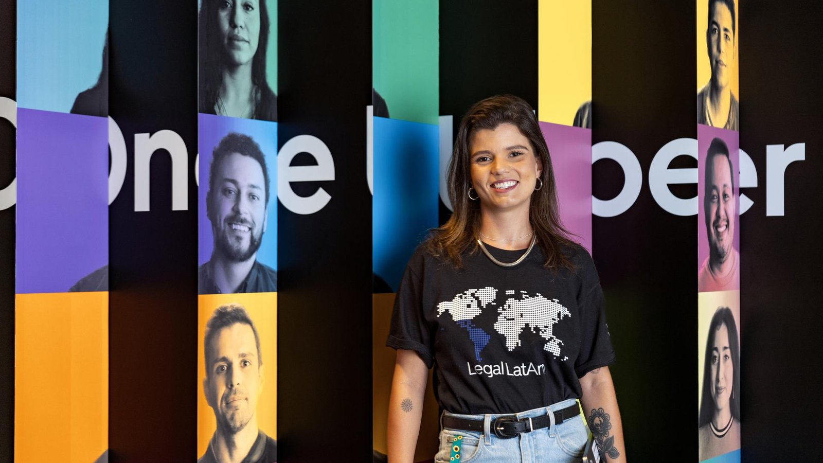 a person standing in front of a wall with persony images of people