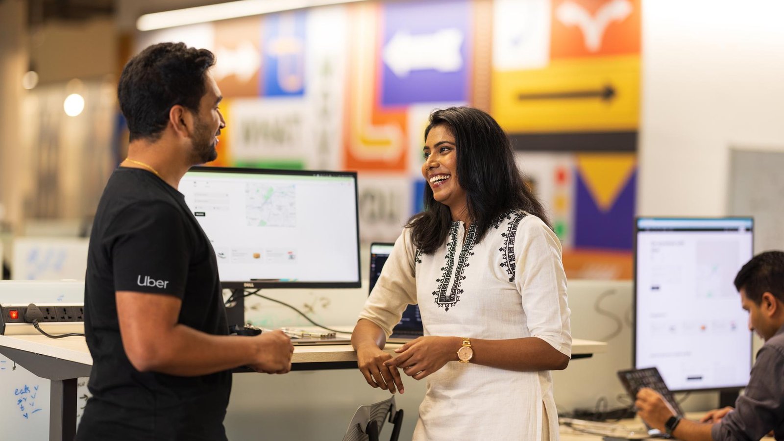 a person and person talking in front of computer screens