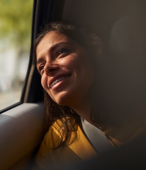a person smiling looking out a window