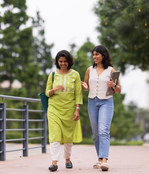 a couple of women walking on a sidewalk