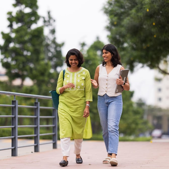 a couple of women walking on a sidewalk