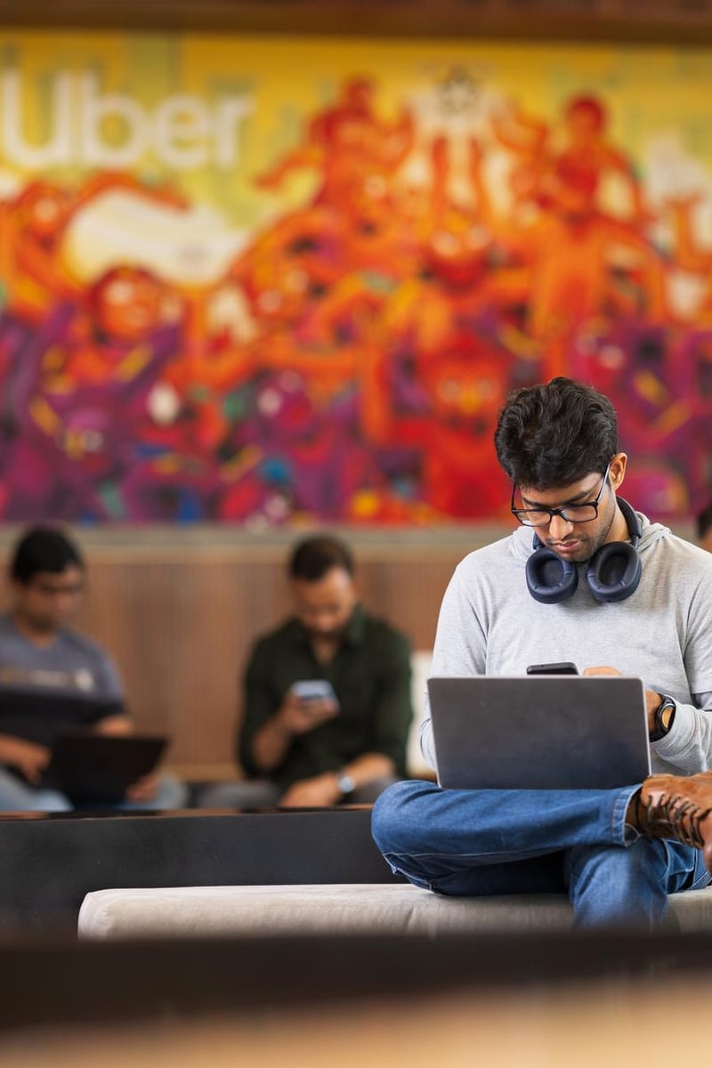 a person sitting on a bench with his legs crossed and headphones on his phone