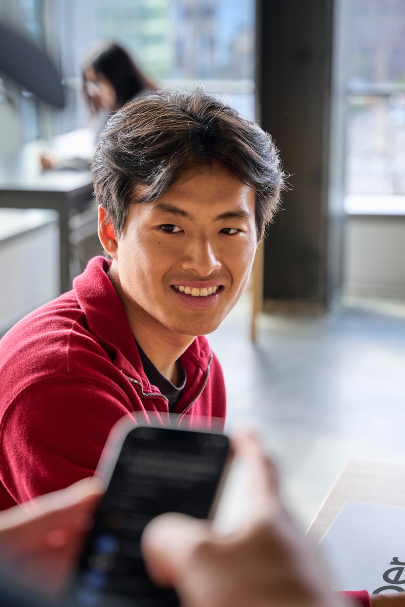 a person smiling at a cell phone