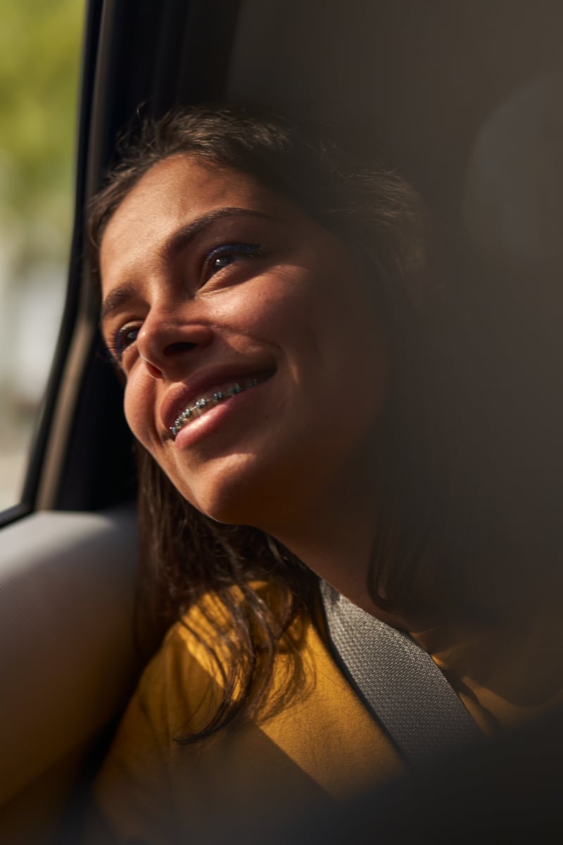 a person smiling looking out a window