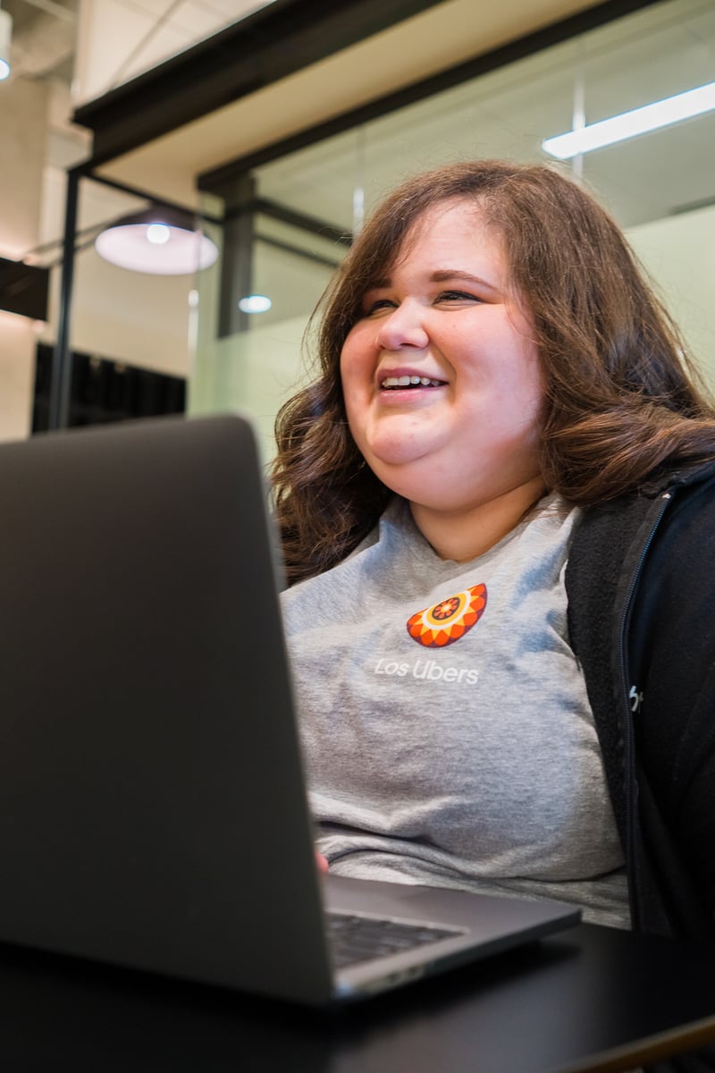 a person smiling at a laptop