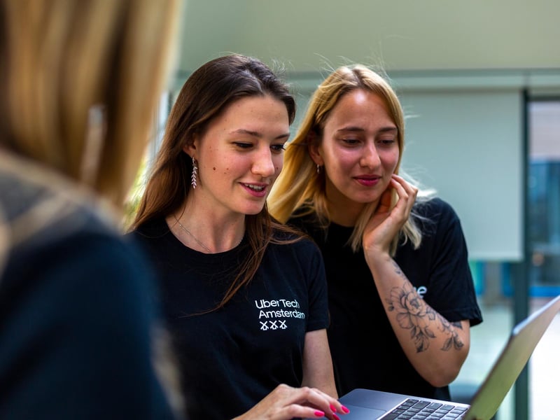 a group of women looking at a laptop