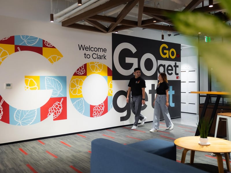 a person and person walking in a room with a large sign