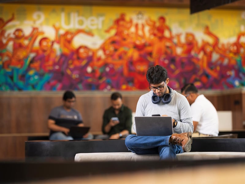 a person sitting on a bench with his legs crossed and headphones on his phone