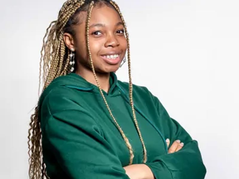 a person with braids wearing a green sweatshirt