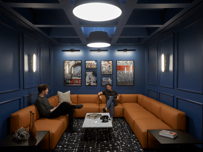 two men sitting on a couch in a room