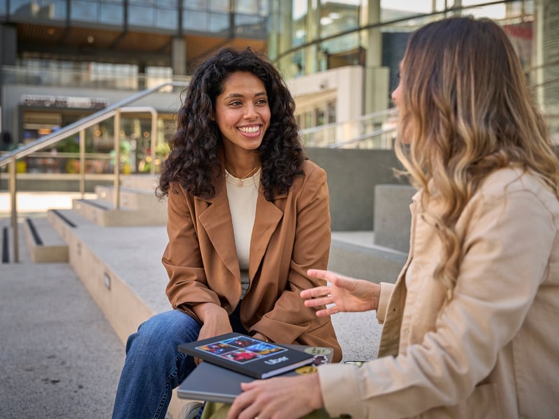 a person sitting on a bench talking to another person