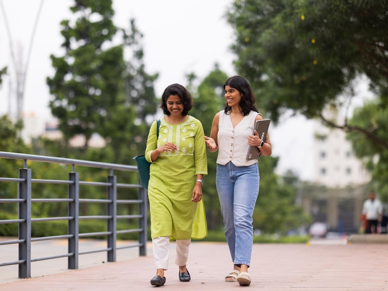 a couple of women walking on a sidewalk
