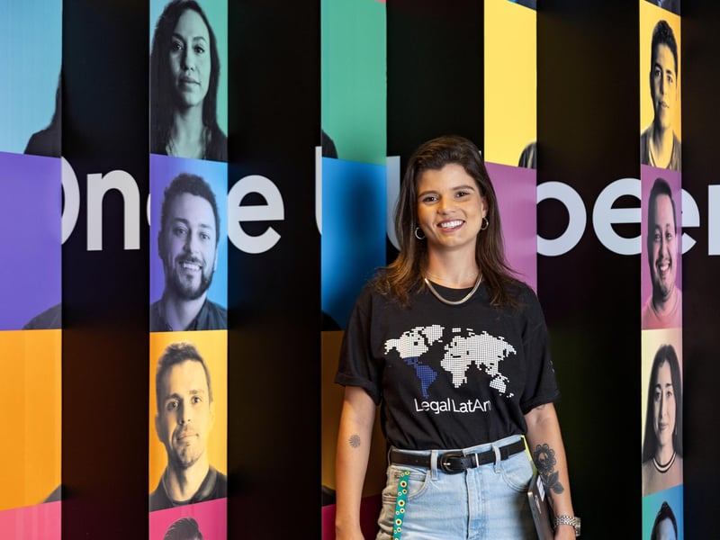a person standing in front of a wall with persony images of people