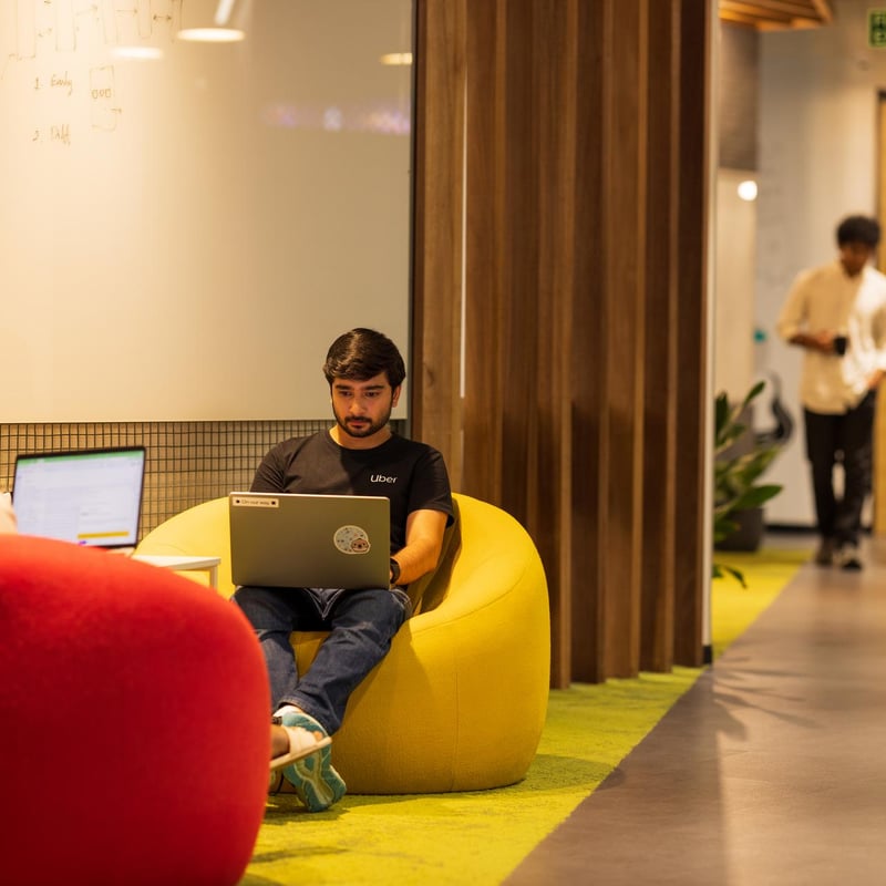 a person sitting in a bean bag chair with a laptop