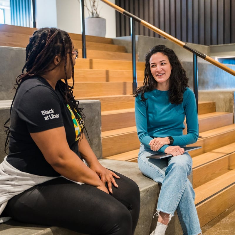 two women sitting on stairs talking