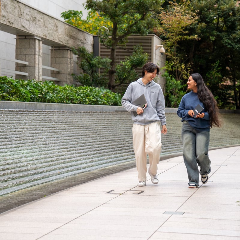 a person and person walking on a sidewalk