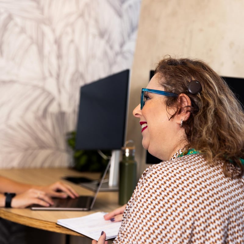 a person sitting at a desk with a computer