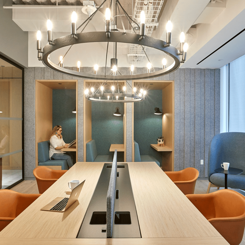 a room with a table and chairs and a person sitting in the background