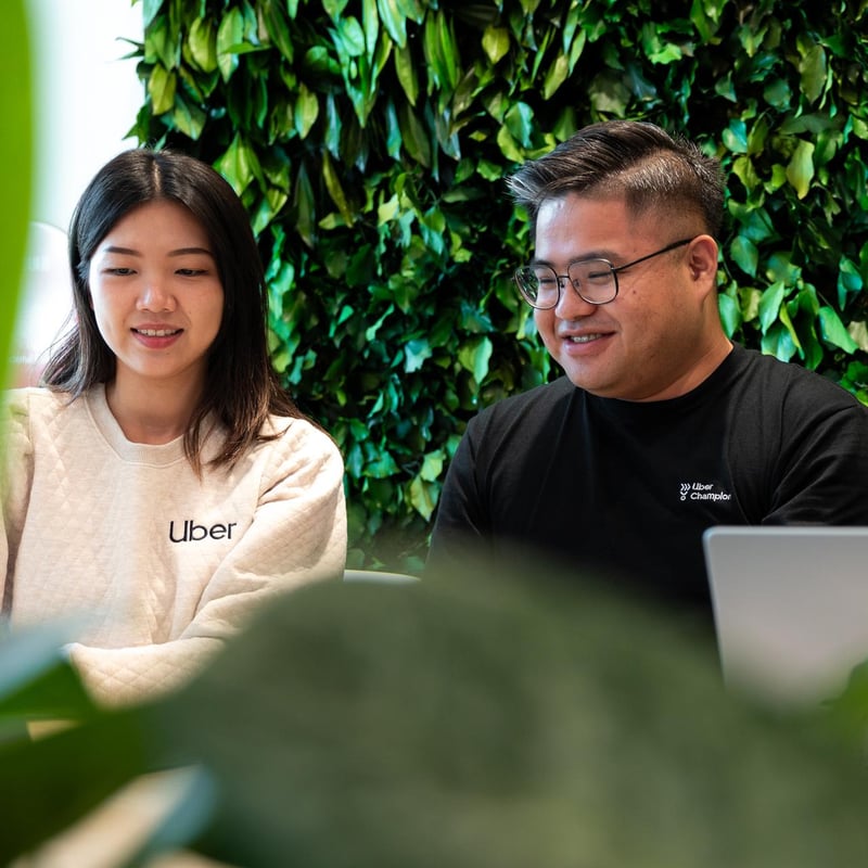 a person and person sitting at a table with a laptop