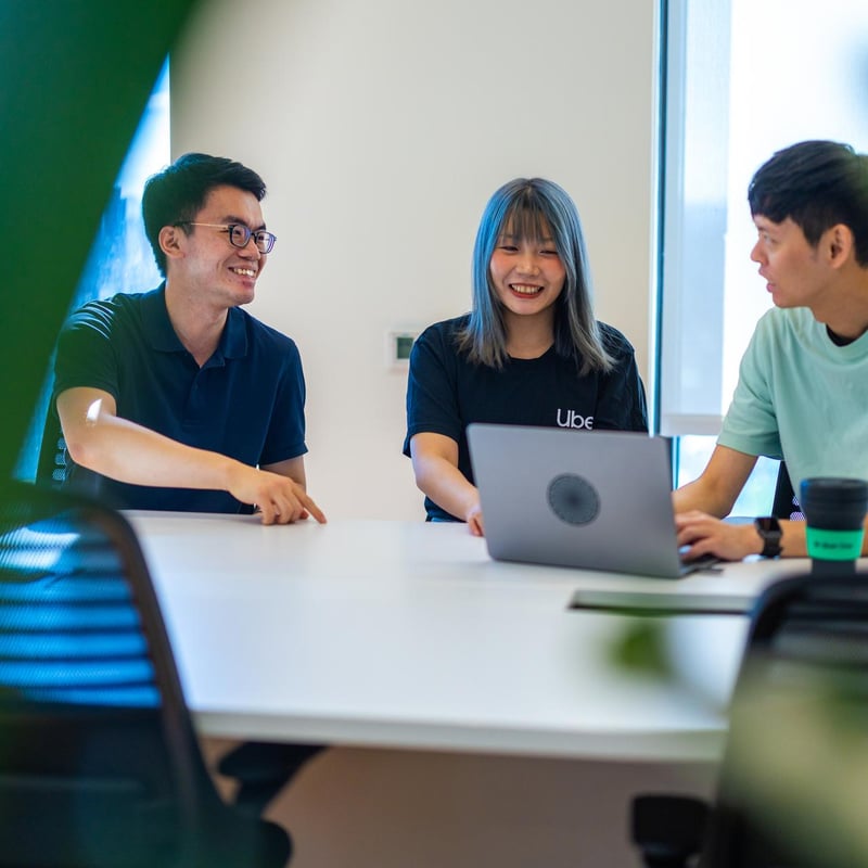a group of people sitting at a table with a laptop