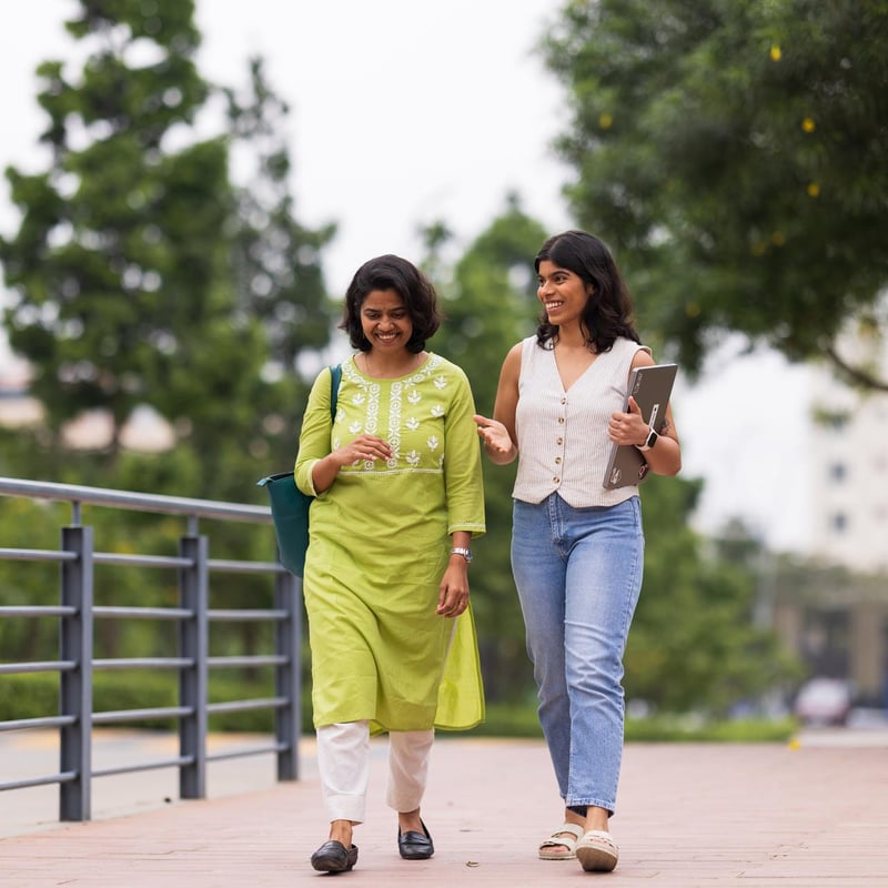 a couple of women walking on a sidewalk