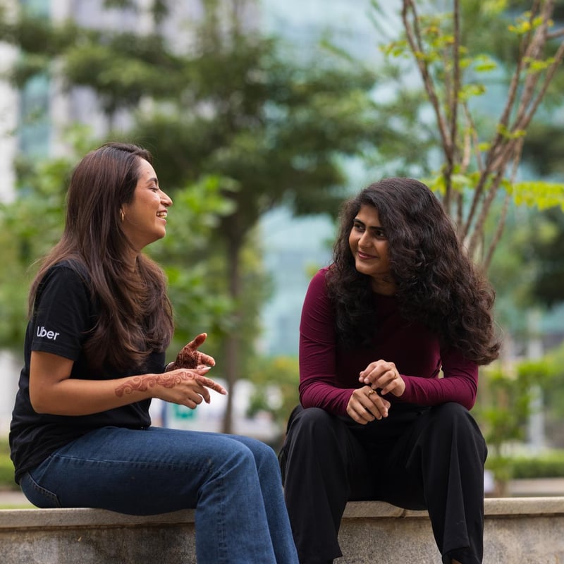 two women sitting on a stone ledge