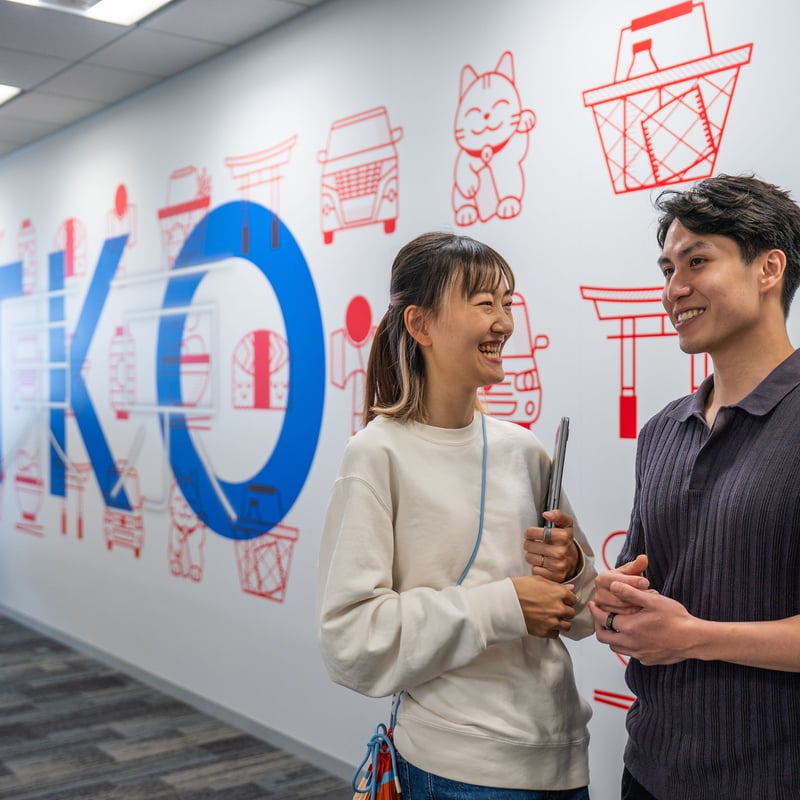 a person and person standing in front of a wall with a sign
