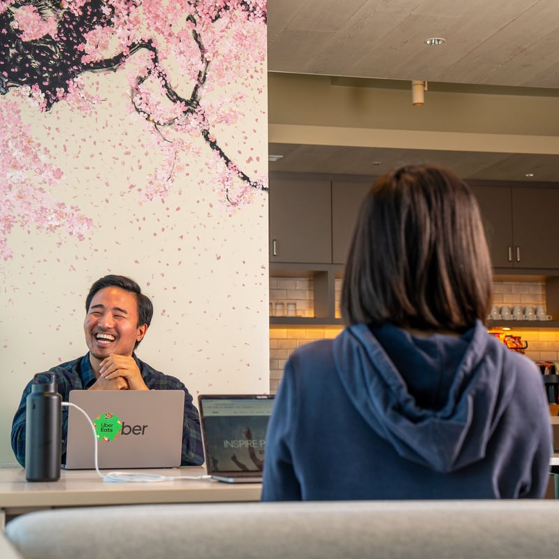 a person sitting at a table with a person in front of him