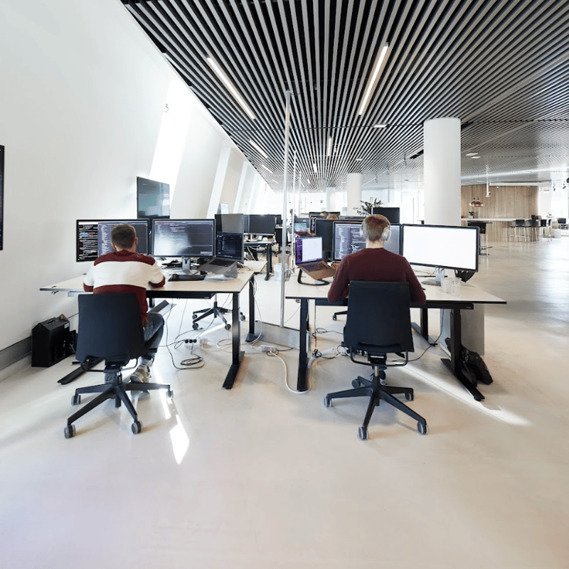a group of people sitting at desks with computers