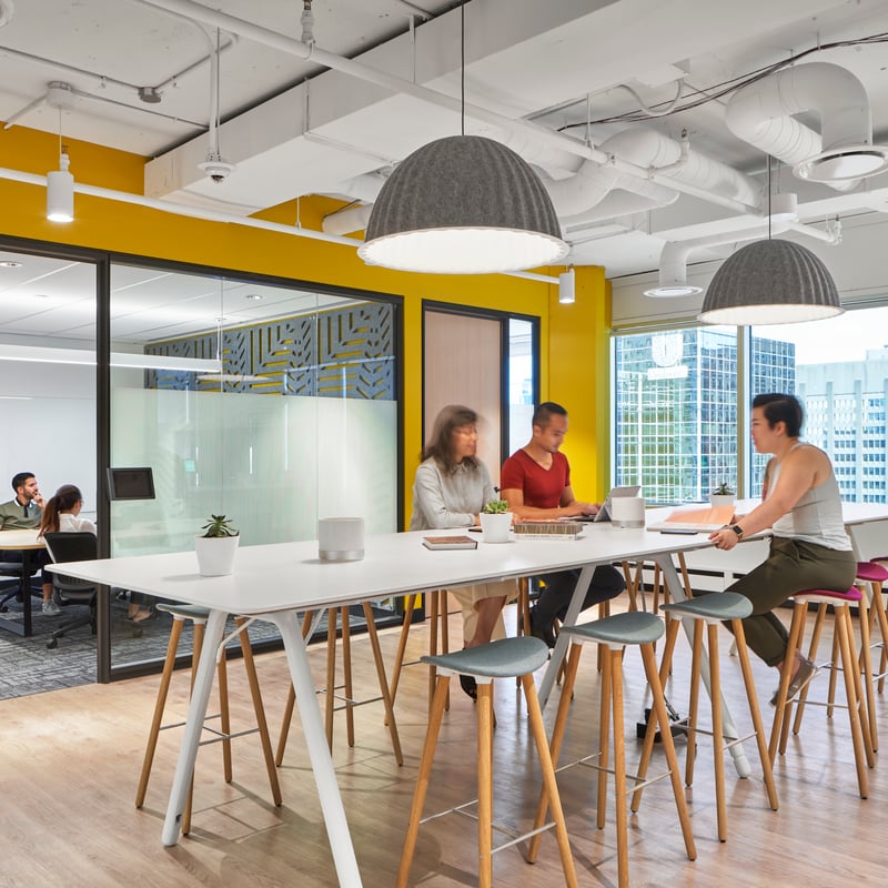 people sitting at a table in a room with yellow walls