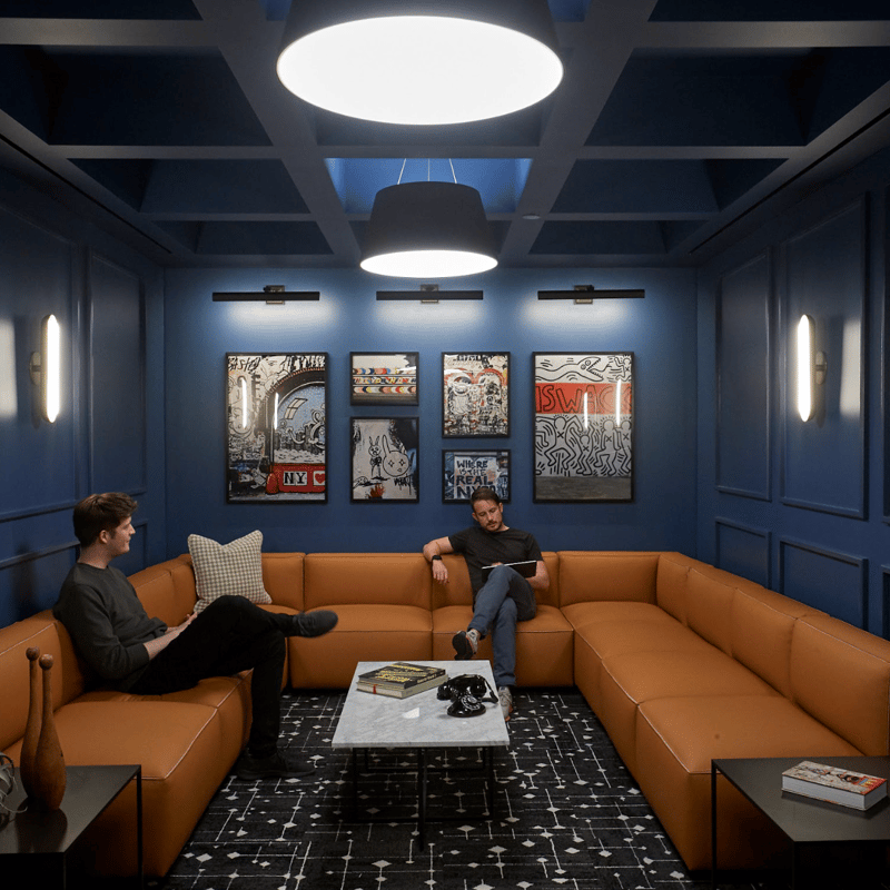 two men sitting on a couch in a room