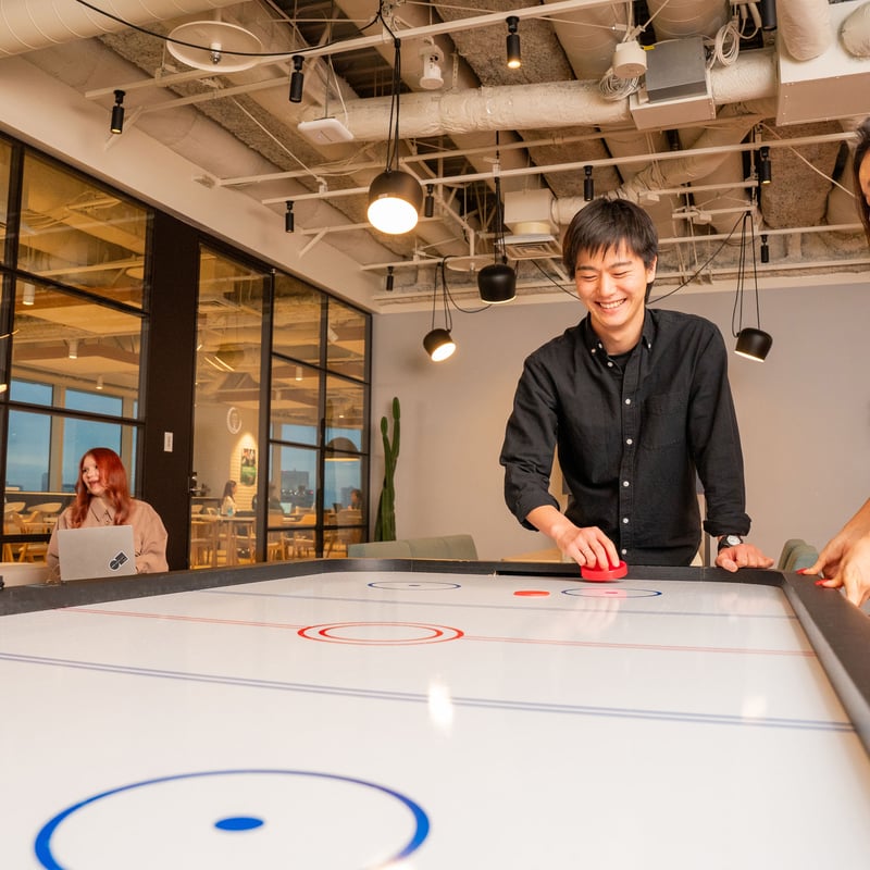 a group of people playing air hockey