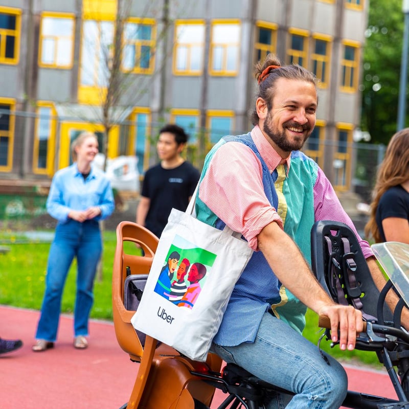 a person riding a bicycle with a bag on his shoulder