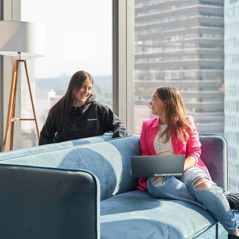 two women sitting on a couch looking at each other
