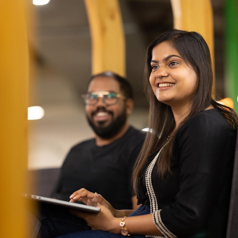 a person smiling while holding a laptop