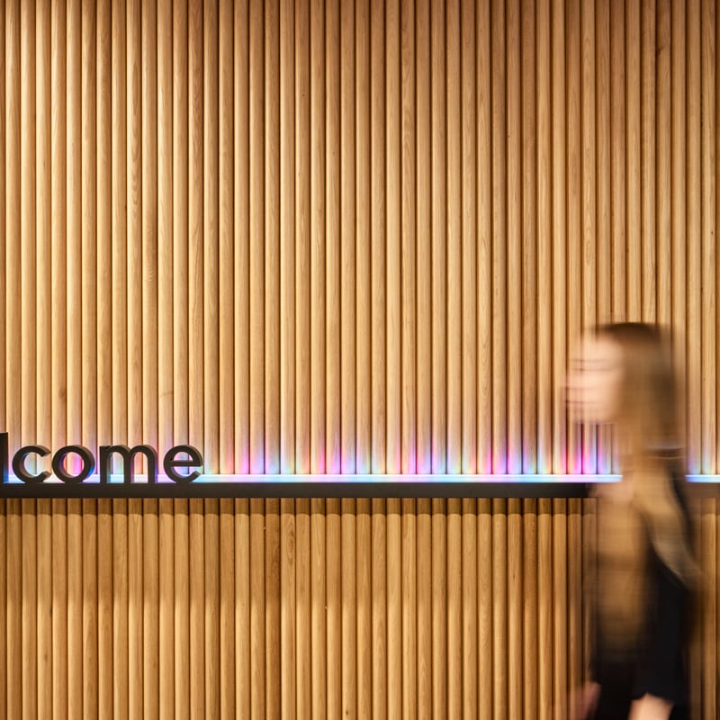 a blurry person walking in front of a welcome sign
