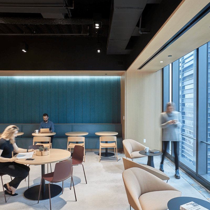 people sitting in a room with tables and chairs
