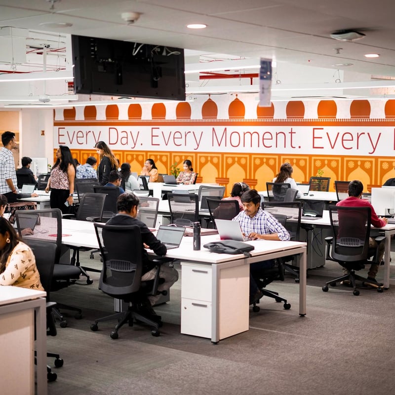 a group of people sitting at desks in an office