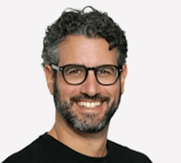 a person with glasses smiling