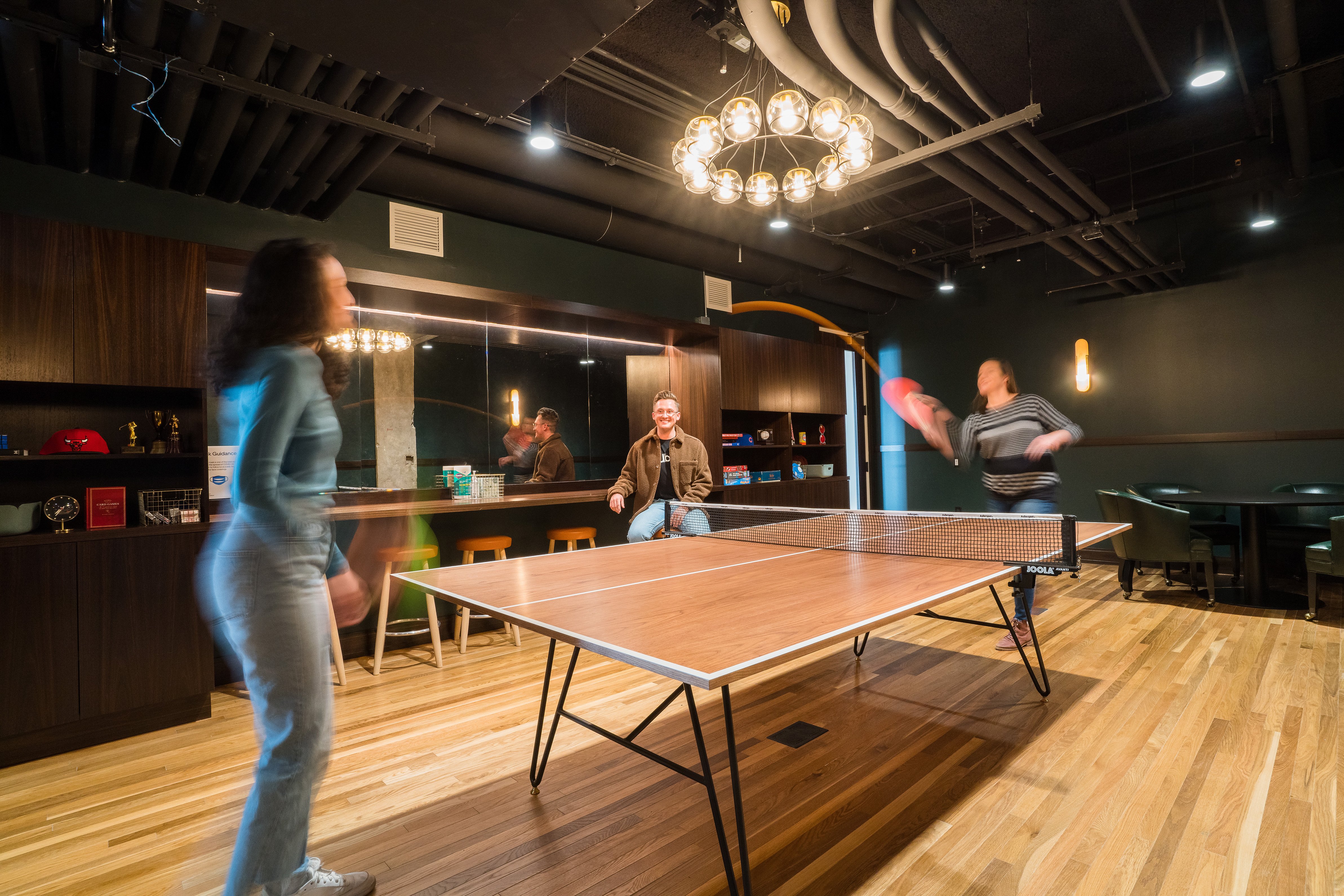 people playing ping pong in a room