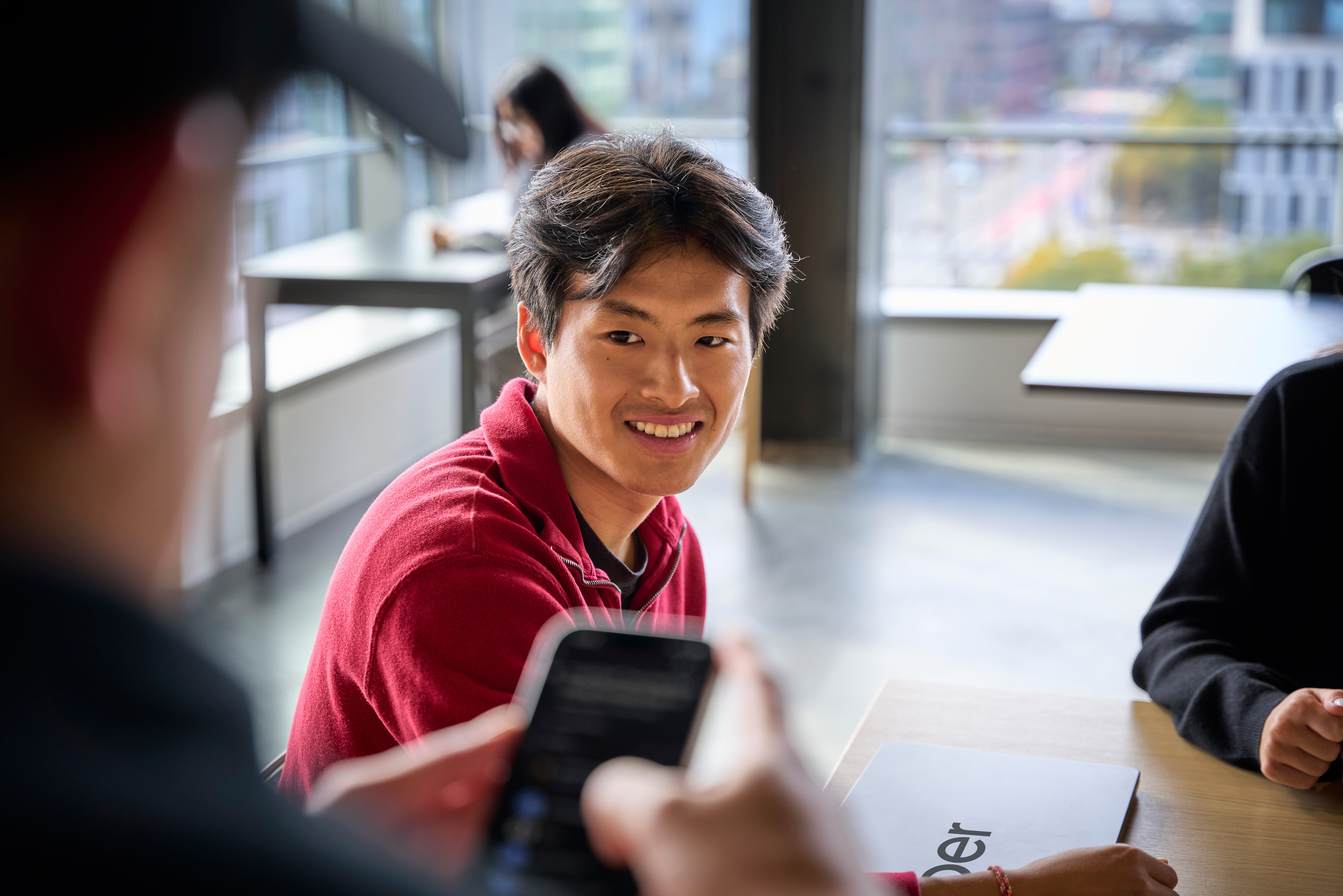 a person smiling at a cell phone