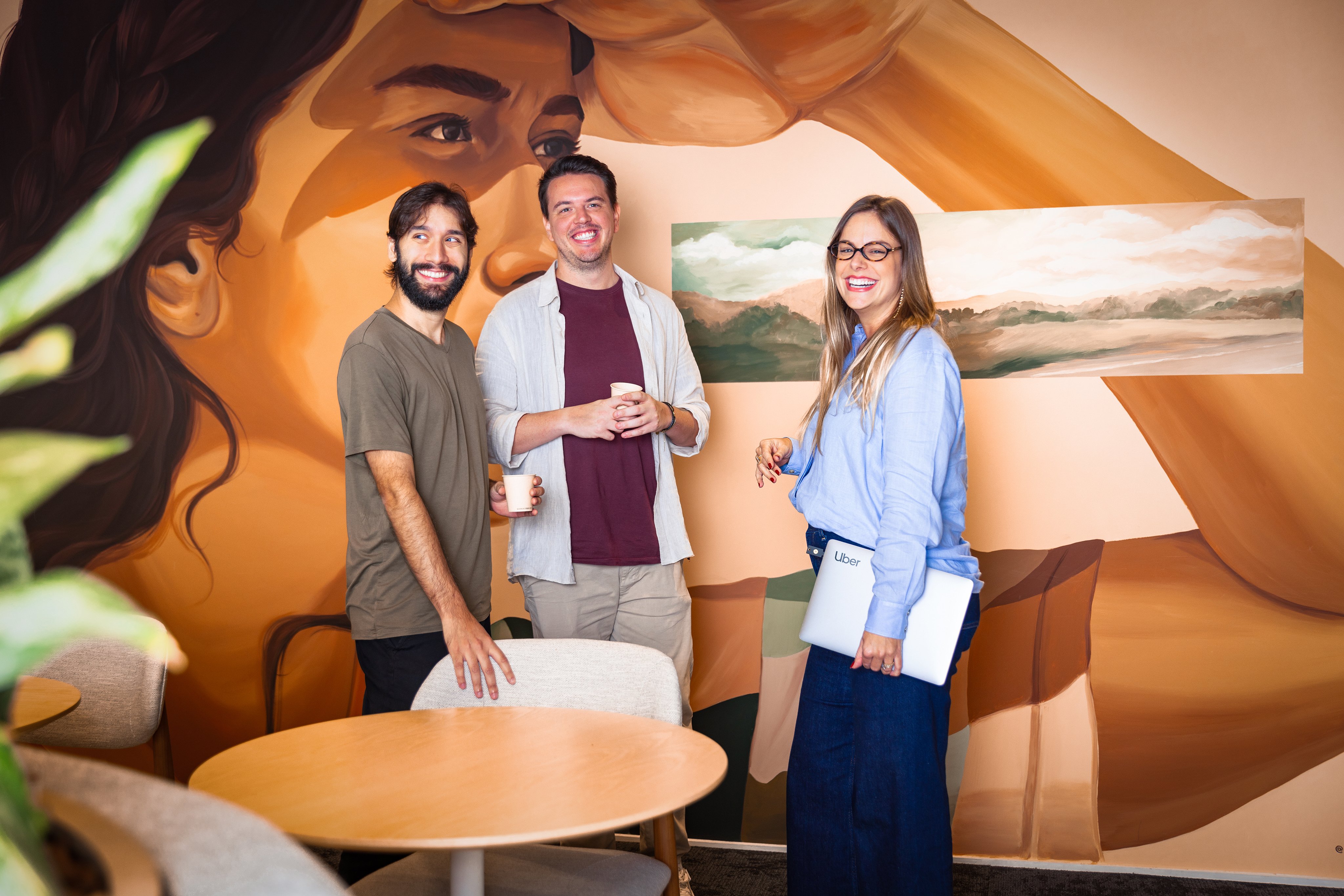 a group of people standing in a room with a mural of a person